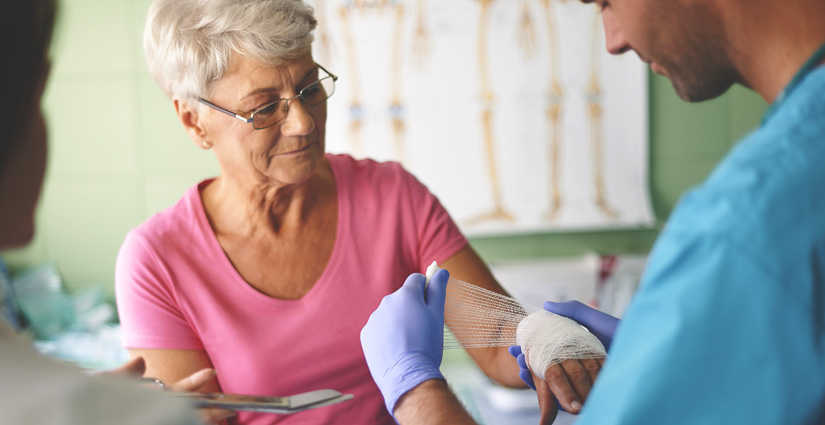 Woman receiving would care treatment to her left hand